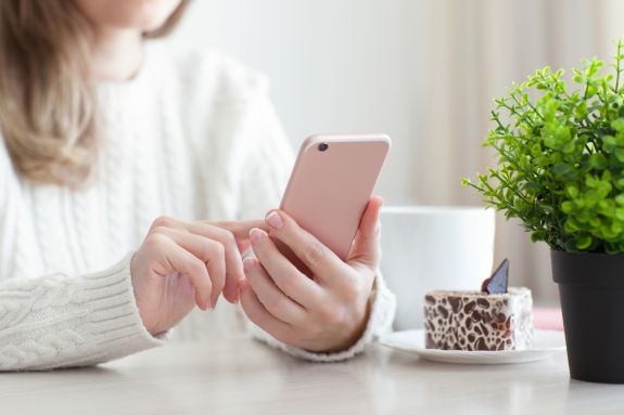 Frau tippt auf ihrem Handy