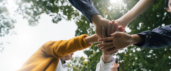 Team hält Hände in die Mitte
