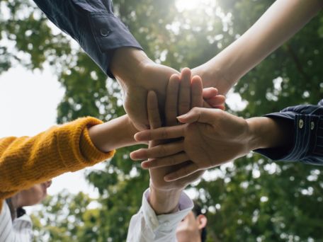 Team hält Hände in die Mitte Team hält Hände in die Mitte