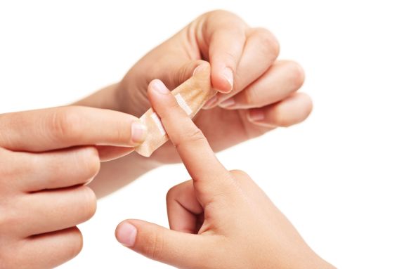 Person putting a plaster on finger