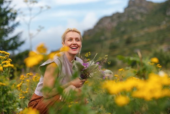 Lächelnde Frau in einer Blumenwiese