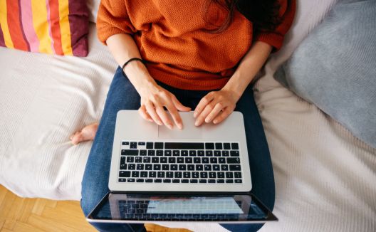 Junge Frau arbeitet an ihrem Laptop